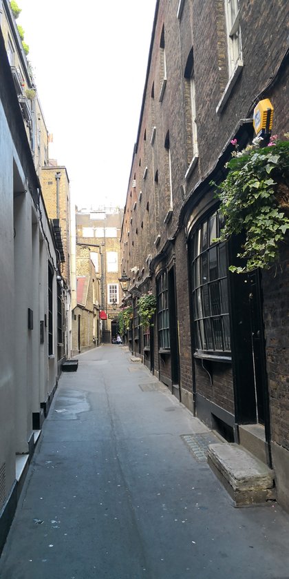 Goodwin's Court, a narrow Georgian passage off St Martin's Lane, its bow-fronted shopfronts lit after dark