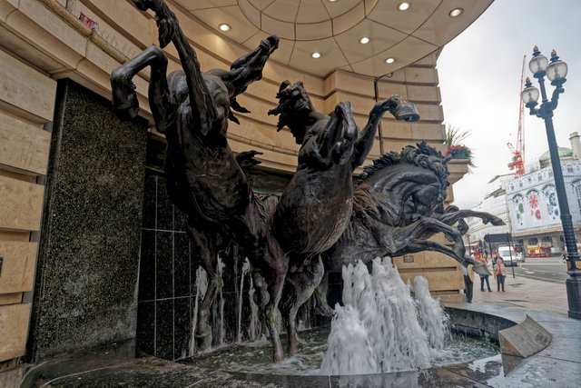 The Horses of Helios, Rudy Weller's 1992 bronze group, breaking out of the pavement at the Haymarket corner of Piccadilly Circus